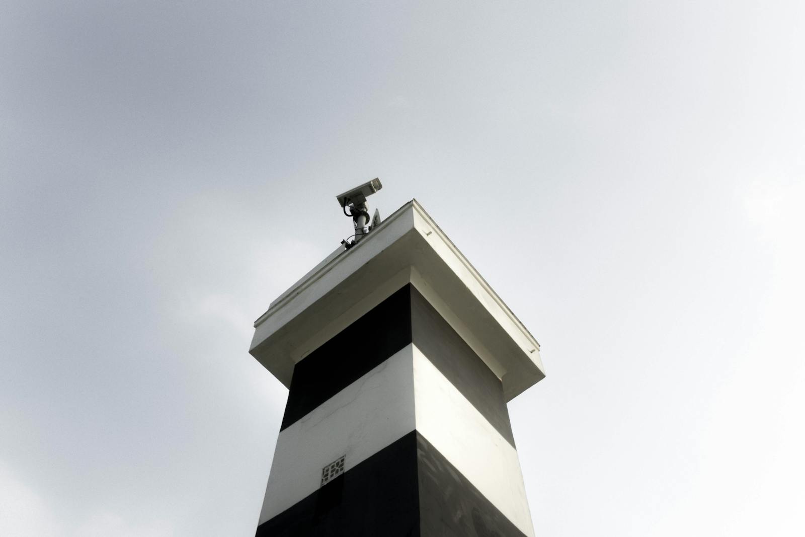 Photo by Maurício Mascaro A modern surveillance tower equipped with a CCTV camera against a clear sky, showcasing security and technology.