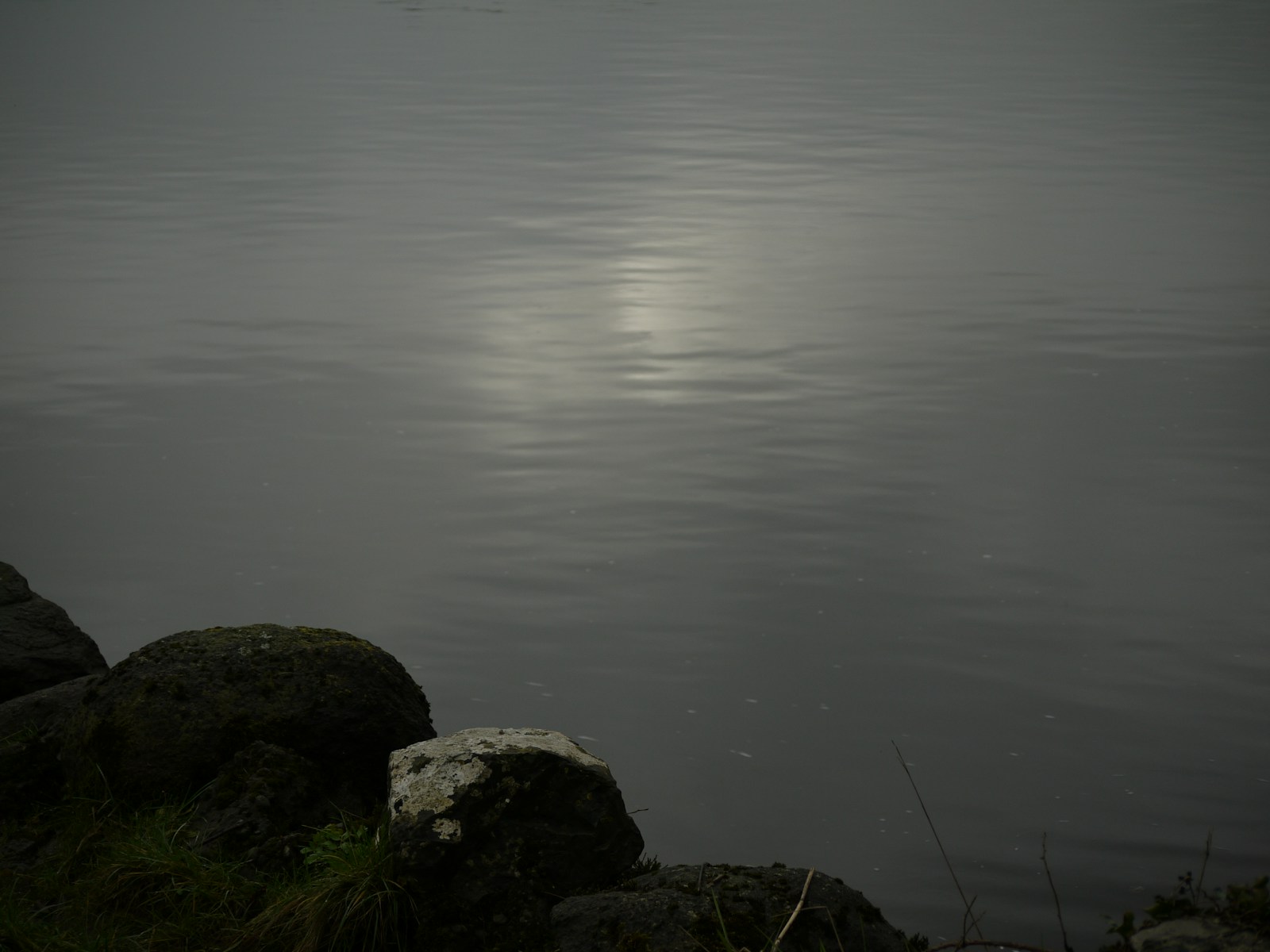 Photo by Fiona Dodd a body of water with rocks in the foreground