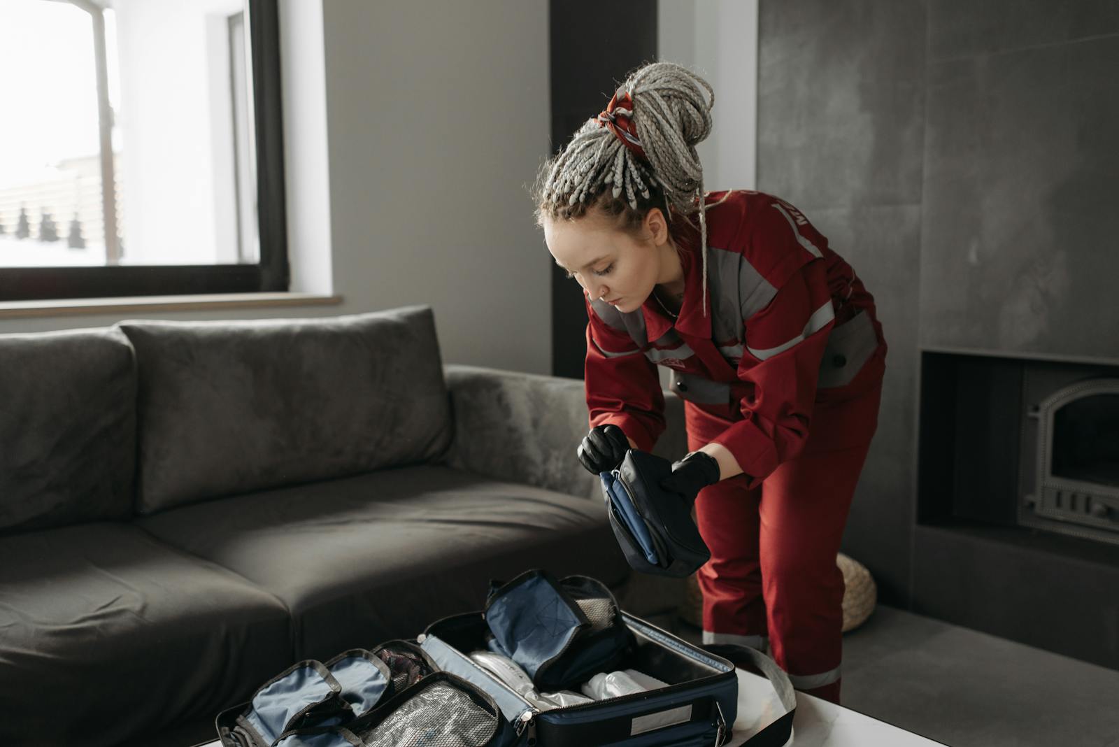 Photo by Pavel Danilyuk Female paramedic methodically unpacks medical kit indoors while preparing for an emergency call.