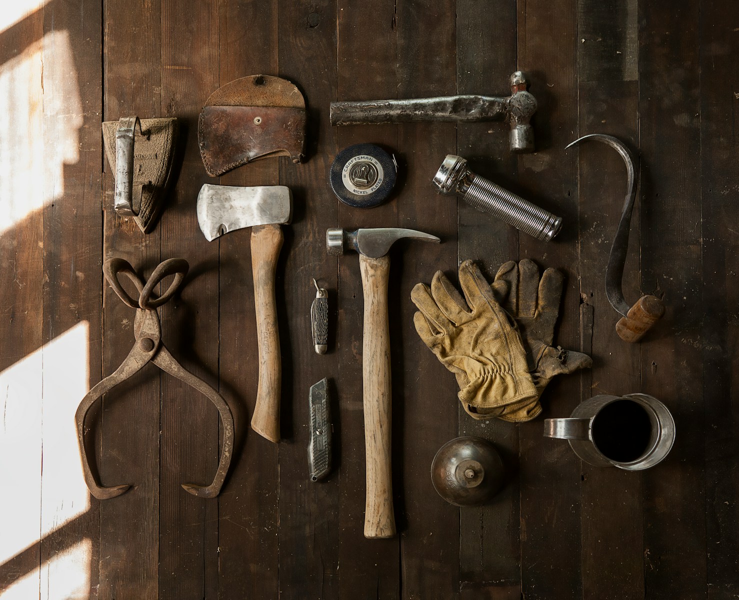 Photo by Todd Quackenbush clothes iron, hammer, axe, flashlight and pitcher on brown wooden table