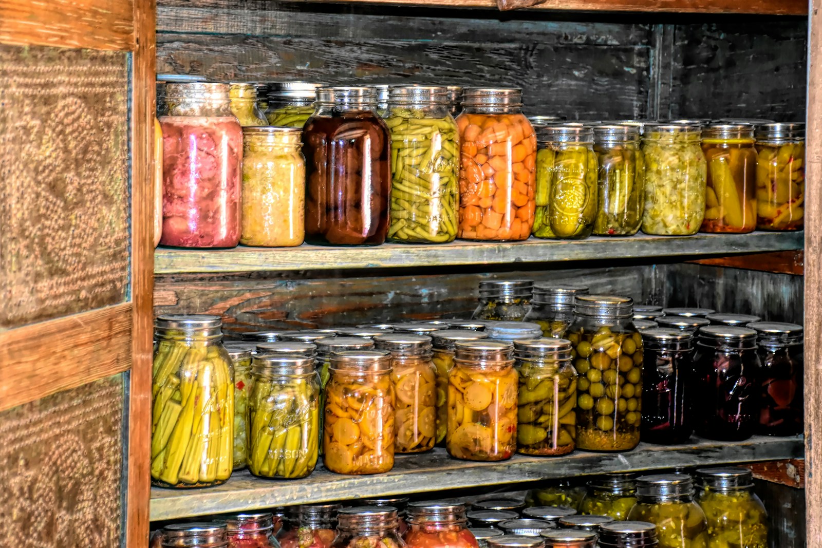 Photo by Ray Shrewsberry a wooden shelf filled with lots of jars of food