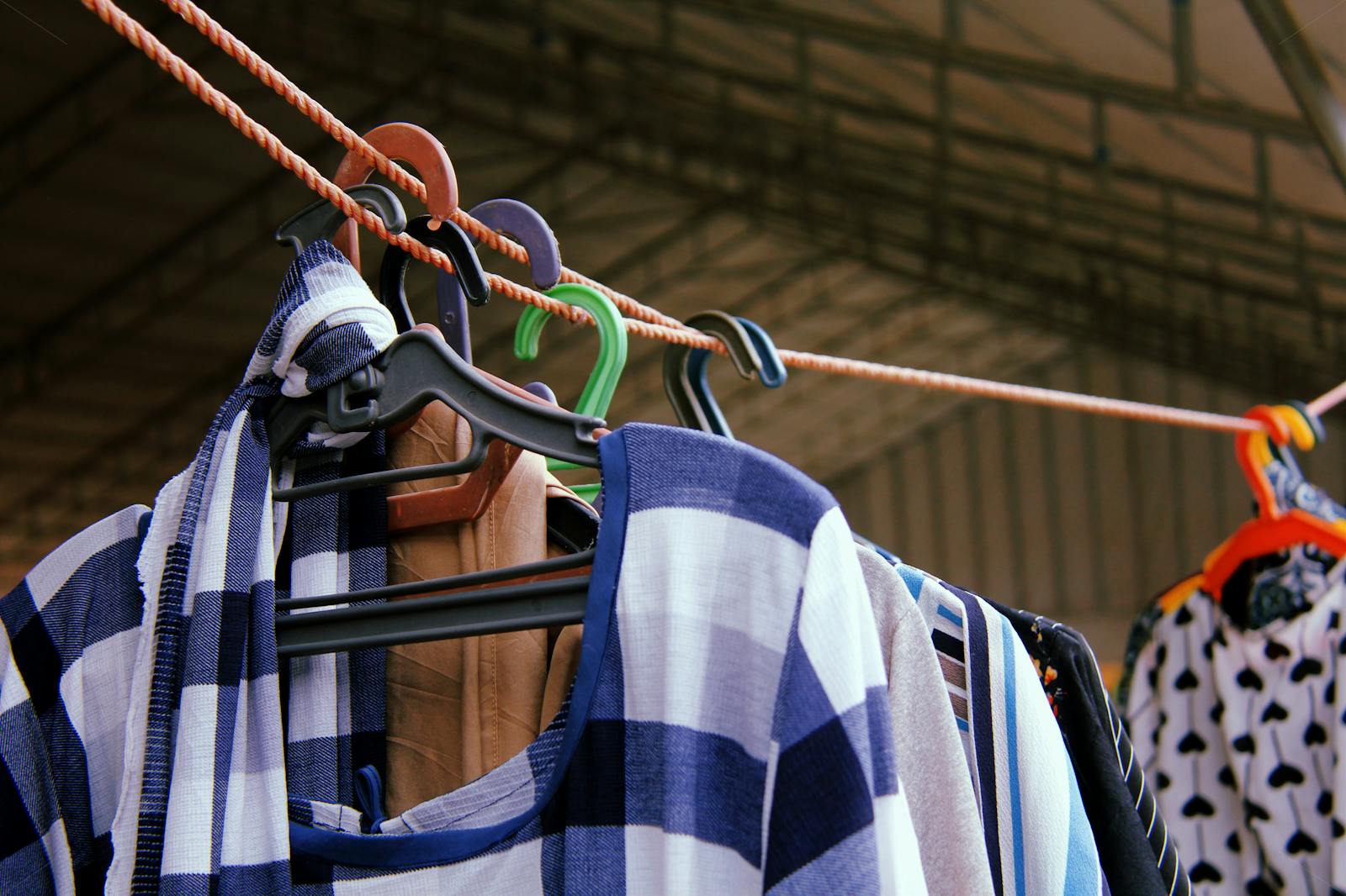 Photo by Muhammad-Taha Ibrahim Close-up of vibrant clothes hanging on a line, showcasing various patterns and colors on hangers.