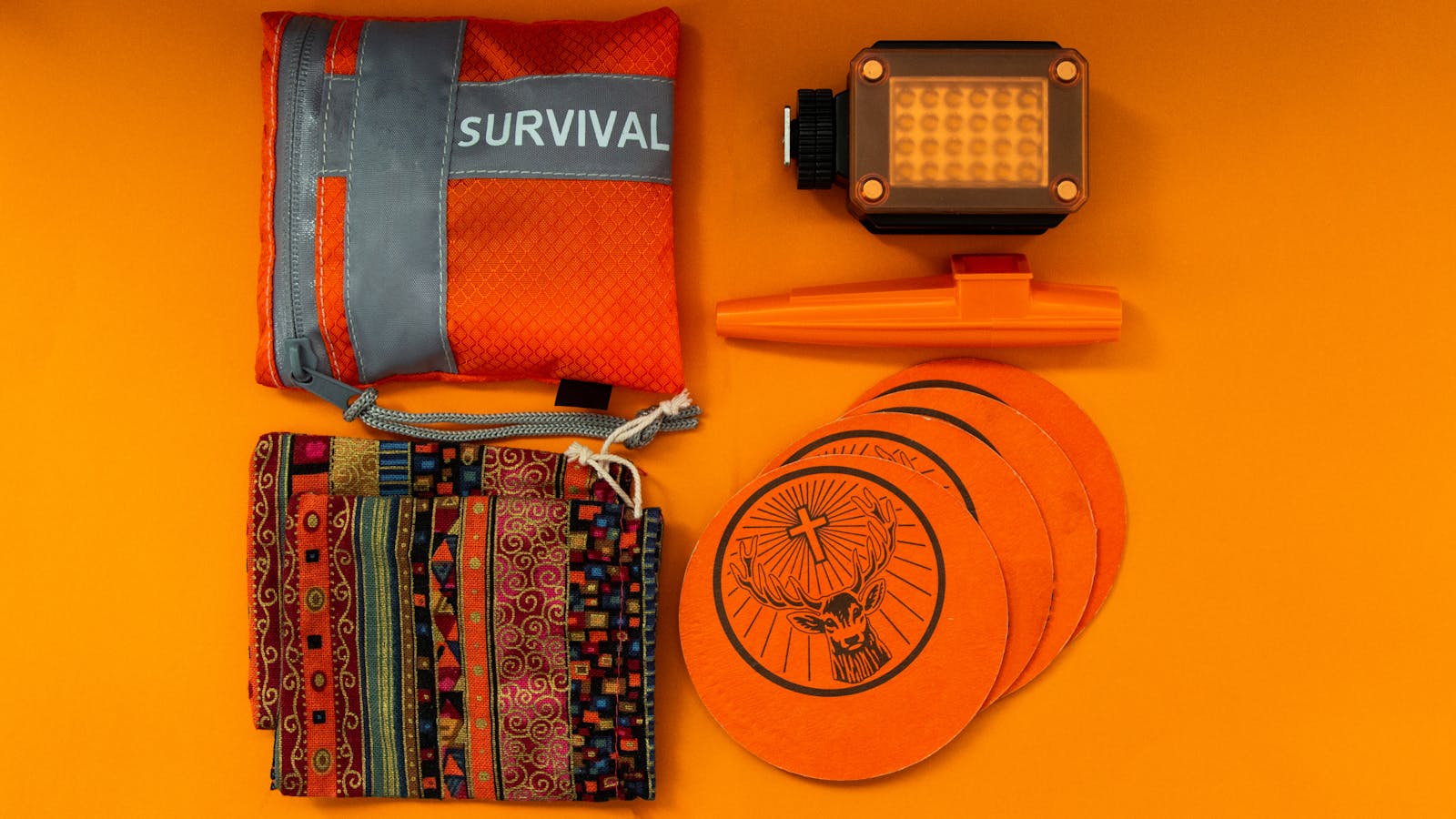 Photo by Aleks Magnusson Flat lay of colorful survival kit items on orange background, showcasing vibrant essentials.