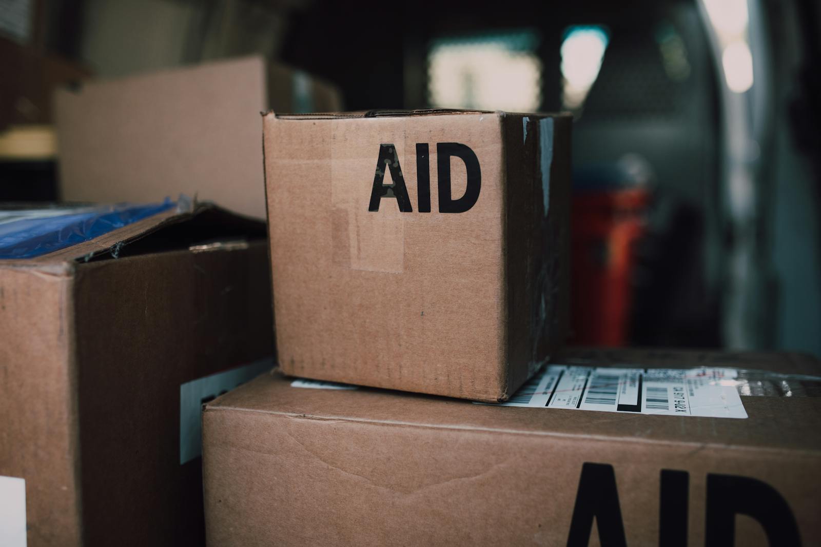 Photo by RDNE Stock project Stacked aid boxes ready for distribution in a delivery vehicle.