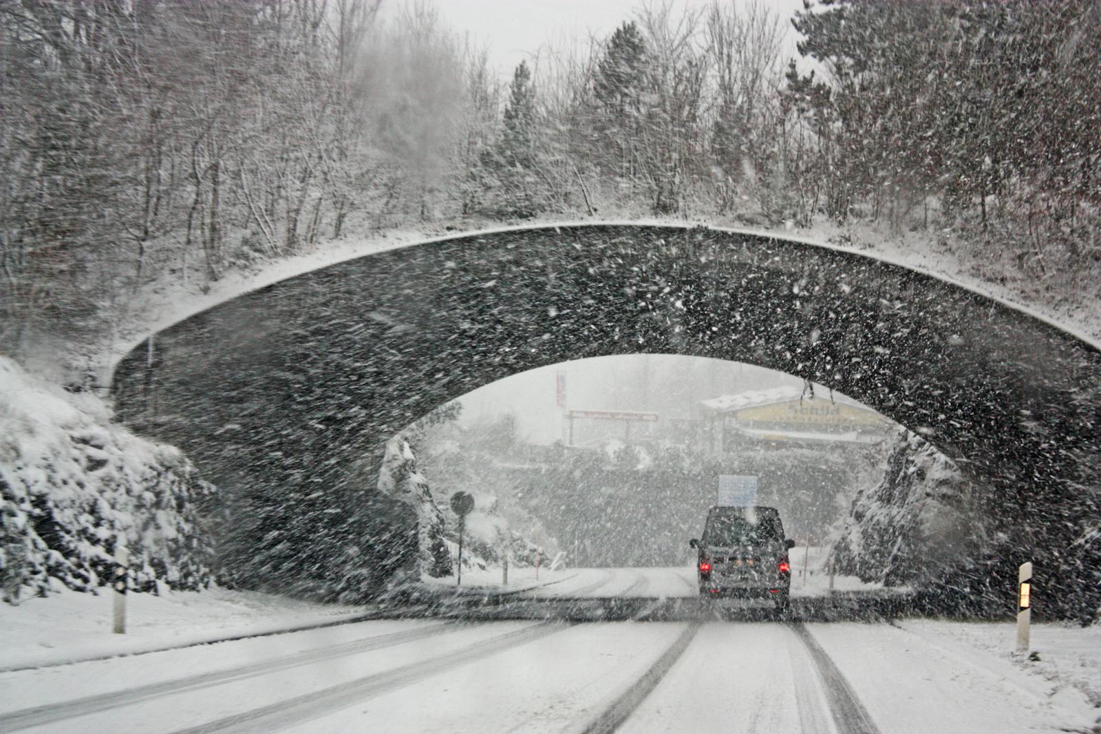 Photo by Magda Ehlers A winter storm covers a Swiss bridge in snow, creating a beautiful yet hazardous landscape.