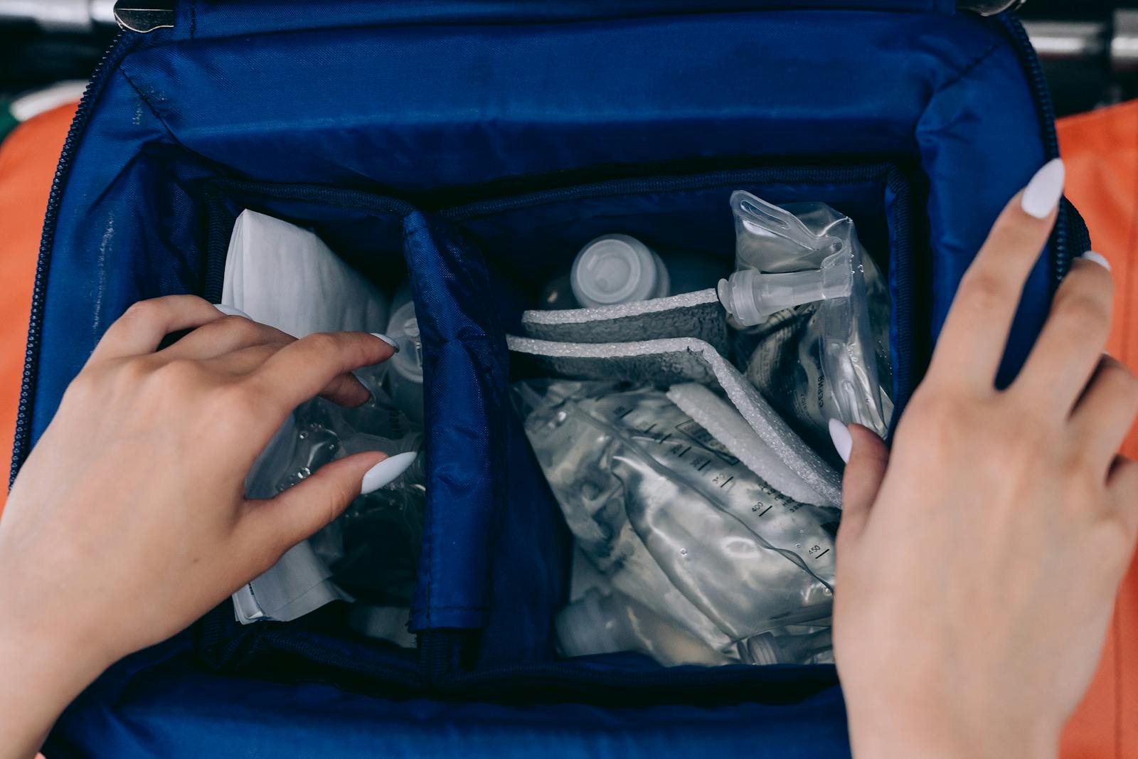 Photo by Mikhail Nilov Close-up of hands opening a medical kit with emergency equipment, showcasing essential preparedness.